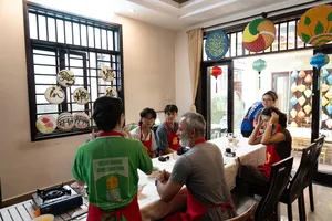 会安 Jolie 烹饪课：客人围坐在共用餐桌旁，在 Jolie 家中一边聊天，一边准备共享的家常餐食