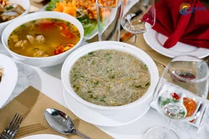 Bowls of soup and sides arranged on a table during dinner on a Sunshine Golden Cruises luxe 2D1N Cat Ba cruise
