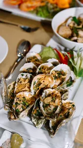 Seafood appetisers on white plates at a private dining table inside a Cat Ba luxury cruise cabin by Sunshine Golden Cruises