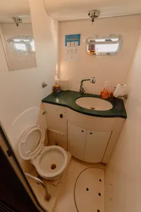 Catamaran bathroom on Mawali in Kota Kinabalu, Sabah, with a green-trimmed sink and toilet for sailing comfort