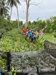 Guests at Kebun Lidstari in Langkawi explore a permaculture vegetable plot, standing among raised beds and lush garden greenery