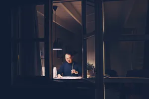 Chong Zheng Calligraphy instructor writing Chinese brush strokes by a window in Singapore, preparing a blessing at workshops in Singapore