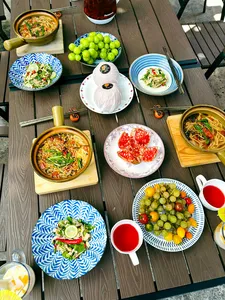 Top-down view of a Lijiang table spread with Yunnan noodles, appetisers and fresh fruit after cooking together