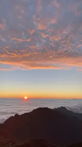 Rising sun breaking through colourful clouds over a sea of mist from Sapa during a 1-day eco trek, at Mt Fansipan