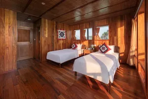Cat Ba Ocean Cruises suite interior on a Cat Ba Boutique Cruise, showing two neatly made beds and bay views