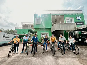 Helmeted cyclists posing outside a Hands Experiences Thailand centre in Khao Lak, ready for a half-day cycling and rafting trip