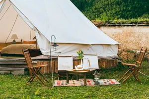 White tent camp with chairs and a serving table by the river during a 2D2N Tibetan stay with Caravan Treks by Ferme Liotard in Shangri-La