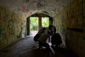 People explore a graffiti-lined tunnel and gather near the bright exit during Fort Serapong Discovery in Singapore hidden gems