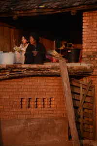 Orang ramai berbual di balkoni inap desa yang sederhana di Xishuangbanna, Yunnan, semasa menginap dengan pengalaman budaya pribumi dan teh