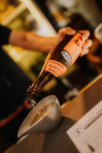 Sake bottle being poured into a small ceramic cup during a rare tasting in a tucked-away shop in Singapore — Singapore hidden gems