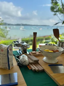 Breakfast cooking setup on a wooden table with a colander of eggs, looking out to the sea at The Unexpected’s Singapore farmstay