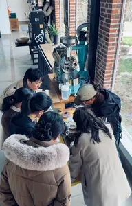 Guests gathered around coffee-making equipment while learning from the family team at Seeker Yunnan Coffee Estate in Lijiang