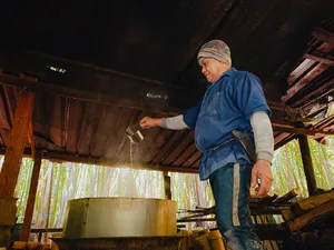 在砂拉越古晋的棕榈糖传统制作过程中,Tanoti Crafts 的主人将棕榈汁倒入一个大型金属锅中