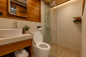 Travass Life phinisi ensuite bathroom with toilet, shower and stone vanity finishes on a Komodo shared trip, Labuan Bajo