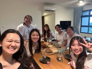 Group of smiling guests at a Singapore baking class table with cups and sliced breads, posing for a photo — workshops in Singapore