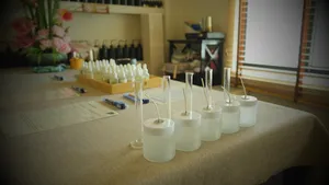 White coco-soy candle jars lined on a table in Singapore, ready for custom scent blending at a perfume workshop
