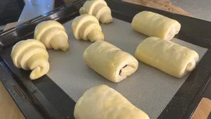 Potongan doh croissant tersusun di atas dulang pembakar beralas tikar silikon, sebahagian daripada bengkel French Cooking Lab di Singapura