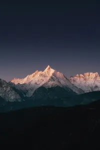 Star-filled night sky over Meili Snow Mountain as dawn light warms the snowy ridges on a 2D2N trek from Shangri-La