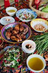 Kota Kinabalu Indigenous Sabahan meal spread with grilled chicken, colourful salads, herbal stems and lit tea-candles