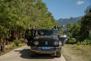 Travellers riding a 4x4 jeep along a mountain road in Shangri-La on a 6-day loop with a Tibetan guide