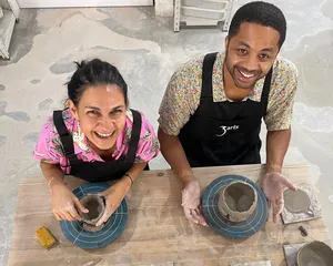 3Arts Pottery hosts smiling while hand-building clay bowls on spinning wheels in a Singapore studio workshop