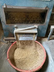 Woven bamboo basket of grains beside a blue sifting machine in a Hanoi Red River village
