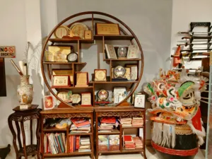 Lion dance costume head and wooden shelves of training manuals and memorabilia inside a kung fu museum in Ho Chi Minh City