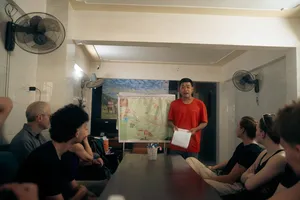 Greenland Tours guide briefing travellers at a table with a wall map in Phong Nha, ready for the cave experience