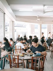 Diners seated at a bright restaurant table during the Joo Chiat food tour together, Singapore hidden gems
