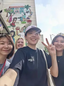Smiling participants posing by a Katong-Joo Chiat mural wall in Singapore during a real-life Monopoly team game  Singapore hidden gems