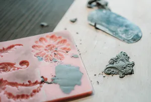 Glazed ceramic plate pieces with floral and decorative moulded details on a studio table during Ina Atelier workshops in Singapore