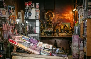 Interior toko yang sempit dipenuhi barang dalam kotak di kedua sisi, dengan altar di tengah, ditampilkan dalam Secrets of the Streets oleh Hidden Heritage tentang hidden gems di Singapura