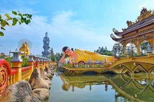 Colourful Mekong pagoda with Buddha statues and a reflecting pool during a Ho Chi Minh City to Mekong private transfer