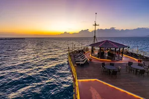 Wooden deck on the Seaventures Dive Rig at sunrise near Semporna, with chairs overlooking the South China Sea