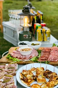 Outdoor picnic spread with charcuterie and grilled skewers on a wooden table during a Mission Liotard day trek in Shangri-La