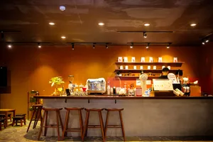Aromatic drink and beverage station inside a Hanoi café for the Rare Agarwood Tour, with espresso machines, shelves and staff at work