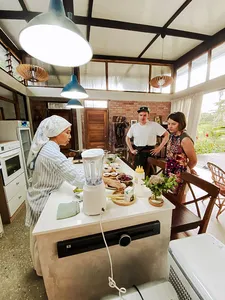Guests cooking Malaysian comfort food at a farmhouse kitchen hosted by Kebun Lidstari on a permaculture farmstay in Langkawi