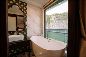 Freestanding bathtub in the ensuite of a Sunshine Golden Cruises suite, with a window view over Cat Ba waters