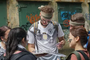 Team members listening as a guide shares clues and points at a map during Fort Serapong’s discovery quest in Singapore
