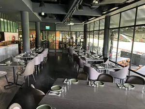 Long dining tables with place settings and glassware in a modern Singapore space for team local produce cooking challenges