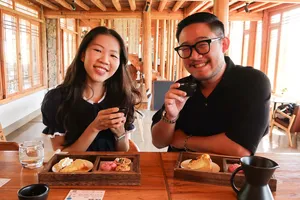 Smiling visitors tasting coffee at Seeker Yunnan Coffee Estate in Lijiang, inside a family-run specialty coffee workshop