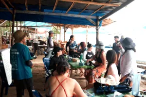 People gathered under a shelter preparing coral planting supplies with Rinca Coral Nursery Program before restoring reefs in Labuan Bajo