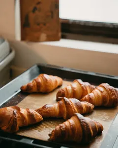 Tray of golden croissants resting on a baking sheet in an oven during a French croissant baking session in Singapore