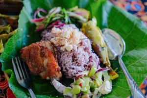 Sabahan meal served on banana leaves in Kota Kinabalu, Borneo, with rice, grilled meat, and fresh vegetables