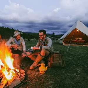 Campfire dinner at a canvas campsite in Shangri-La’s remote valleys, with travellers cooking beside a lantern-lit tent
