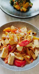 Chopped vegan vegetables and tomato salad on ceramic plates during a Traditional Manggarai cooking class in Labuan Bajo