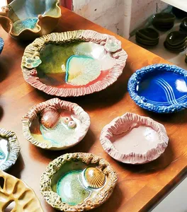 Glazed Ilham Ceramic dishes and bowls on a wooden table, showcasing Langkawi pottery in the village studio