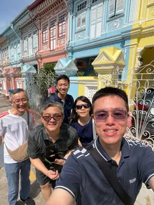 Team members smiling for a selfie outside Peranakan shophouses in Katong-Joo Chiat during a Monopoly-style trail in Singapore hidden gems.