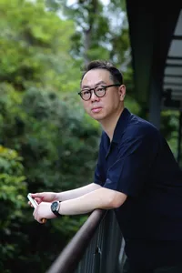 Chong Zheng Calligraphy instructor holding a calligraphy brush outdoors during a write-your-own blessing session—workshops in Singapore