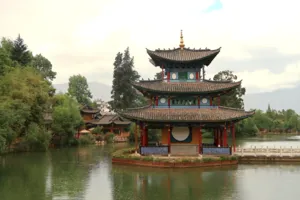 Traditional Naxi pavilion on a small island above a pond, with Naxi-style buildings in Shuhe Ancient Town, Lijiang